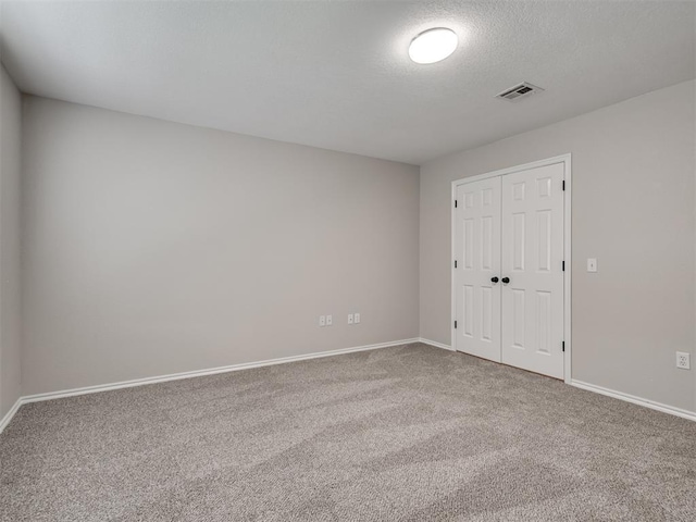 3004 Twin Lake Dr, Moore, OK 73165 - unfurnished bedroom with carpet, a closet, and a textured ceiling
