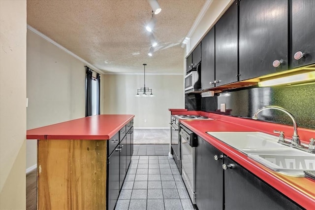 6100 N Brookline Ave Unit 2, Oklahoma City, OK 73112 - kitchen with crown molding, track lighting, dark cabinetry, a kitchen island, and appliances with stainless steel finishes