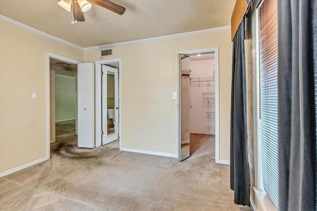 6100 N Brookline Ave Unit 2, Oklahoma City, OK 73112 - unfurnished bedroom with carpet flooring, ornamental molding, a textured ceiling, a walk in closet, and a ceiling fan