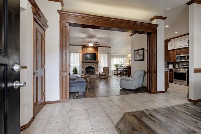 10633 NW 38th St, Yukon, OK 73099 - living area with a large fireplace, light tile patterned floors, crown molding, and ceiling fan
