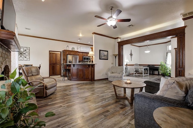 10633 NW 38th St, Yukon, OK 73099 - living room with light wood-style floors, crown molding, ceiling fan, and a fireplace