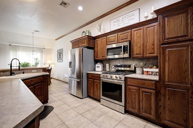 10633 NW 38th St, Yukon, OK 73099 - kitchen with appliances with stainless steel finishes, tasteful backsplash, light tile patterned flooring, pendant lighting, and crown molding
