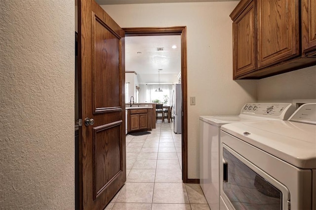 10633 NW 38th St, Yukon, OK 73099 - laundry area with cabinet space, separate washer and dryer, a textured wall, and light tile patterned flooring