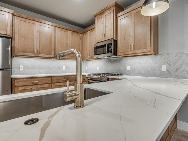 609 W 2nd St, Edmond, OK 73003 - kitchen with stainless steel appliances, light stone countertops, and backsplash