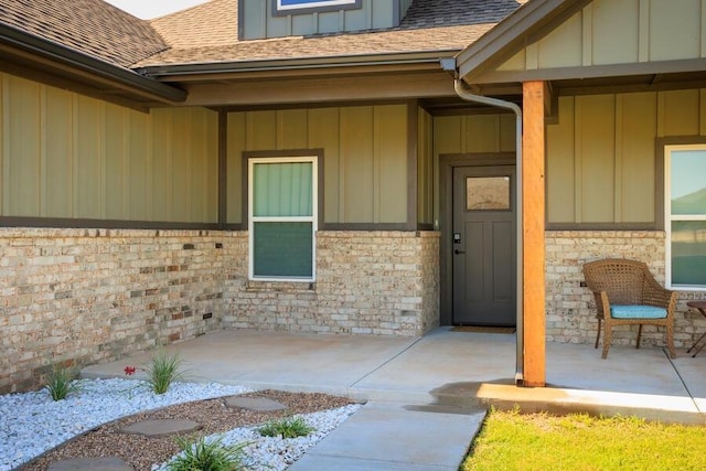 9228 NW 144th Pl, Yukon, OK 73099 - view of exterior entry featuring board and batten siding and a shingled roof