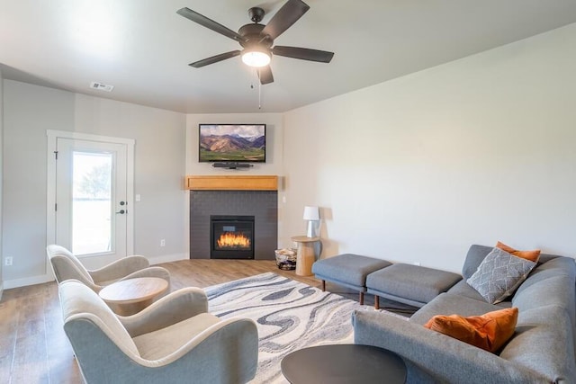 9228 NW 144th Pl, Yukon, OK 73099 - living area featuring wood finished floors, ceiling fan, and a glass covered fireplace