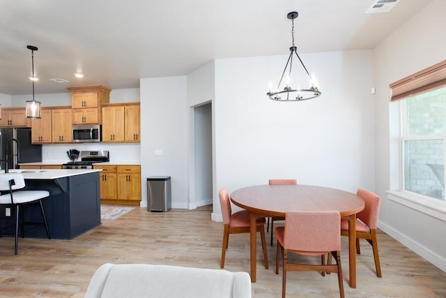 9228 NW 144th Pl, Yukon, OK 73099 - kitchen with stainless steel appliances, a chandelier, light countertops, and light wood-style flooring
