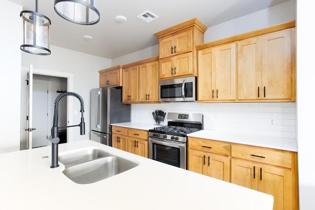 9228 NW 144th Pl, Yukon, OK 73099 - kitchen featuring stainless steel appliances, light countertops, backsplash, light brown cabinets, and hanging light fixtures