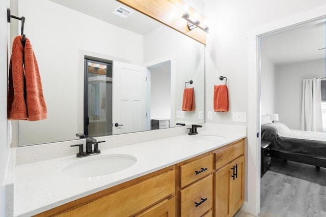 9228 NW 144th Pl, Yukon, OK 73099 - bathroom featuring connected bathroom, double vanity, and wood finished floors