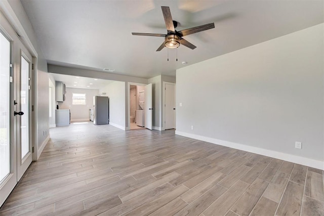1317 E Boyd St, Norman, OK 73071 - unfurnished living room featuring ceiling fan, light wood finished floors, and washer / clothes dryer