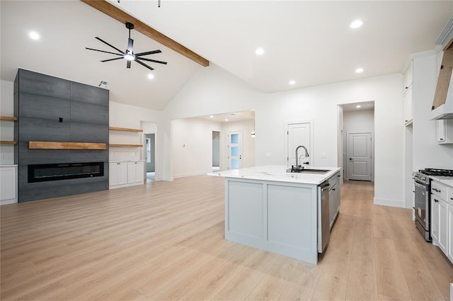 2705 NW 40th St, Oklahoma City, OK 73112 - kitchen featuring stainless steel appliances, beamed ceiling, open floor plan, a fireplace, and light countertops