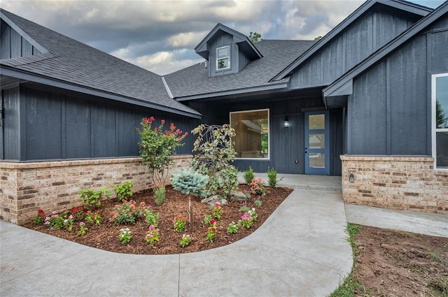 2705 NW 40th St, Oklahoma City, OK 73112 - entrance to property featuring a shingled roof, brick siding, and board and batten siding