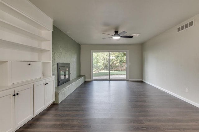 3325 NW 65th St Unit 4057723241, Oklahoma City, OK 73116 - unfurnished living room with a large fireplace, ceiling fan, and dark wood finished floors