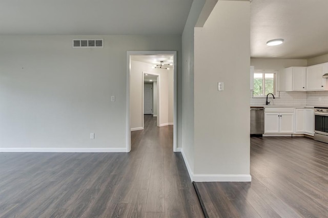3325 NW 65th St Unit 4057723241, Oklahoma City, OK 73116 - unfurnished living room featuring dark wood-type flooring and a chandelier