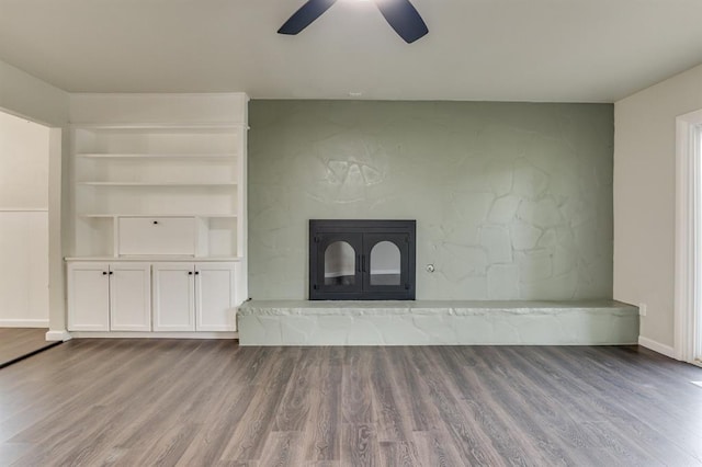 3325 NW 65th St Unit 4057723241, Oklahoma City, OK 73116 - unfurnished living room featuring wood finished floors, a ceiling fan, and a glass covered fireplace