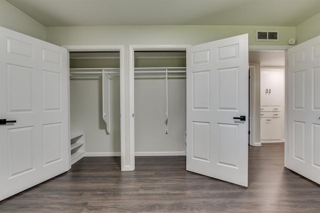 3325 NW 65th St Unit 4057723241, Oklahoma City, OK 73116 - unfurnished bedroom featuring multiple closets and dark wood-style floors