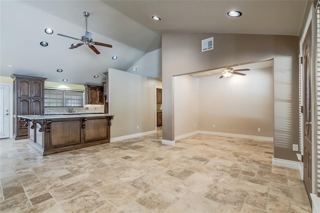 6704 Tall Oaks Dr, Oklahoma City, OK 73127 - kitchen featuring ceiling fan, open floor plan, light stone finish flooring, dark brown cabinetry, and high vaulted ceiling