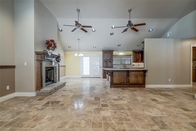 6704 Tall Oaks Dr, Oklahoma City, OK 73127 - kitchen with ceiling fan, stone tile flooring, open floor plan, high vaulted ceiling, and a tile fireplace