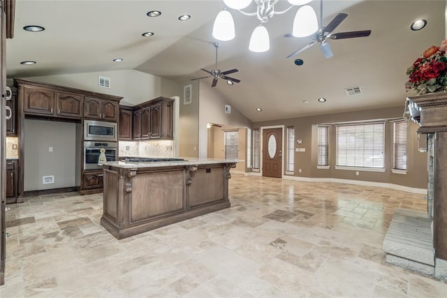 6704 Tall Oaks Dr, Oklahoma City, OK 73127 - kitchen with stainless steel appliances, a ceiling fan, vaulted ceiling, stone tile flooring, and open floor plan
