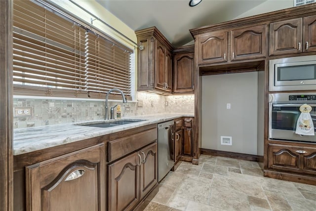 6704 Tall Oaks Dr, Oklahoma City, OK 73127 - kitchen with appliances with stainless steel finishes, decorative backsplash, stone tile flooring, and light stone countertops