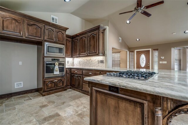 6704 Tall Oaks Dr, Oklahoma City, OK 73127 - kitchen with stainless steel appliances, lofted ceiling, ceiling fan, backsplash, and dark brown cabinetry
