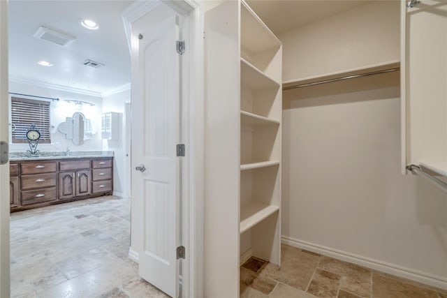 6704 Tall Oaks Dr, Oklahoma City, OK 73127 - walk in closet with light stone finish floors and a sink