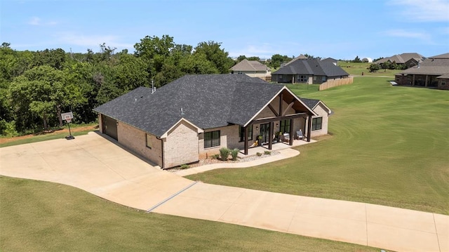 1074 Fawn Meadow Dr, Blanchard, OK 73010 - view of front of property with a front yard, concrete driveway, a shingled roof, brick siding, and a porch