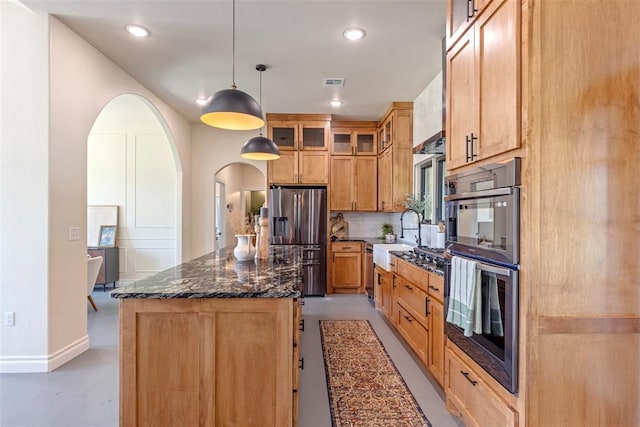 1074 Fawn Meadow Dr, Blanchard, OK 73010 - kitchen with appliances with stainless steel finishes, a kitchen island, glass insert cabinets, finished concrete flooring, and dark stone countertops