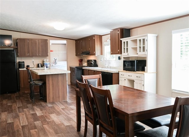 16940 Wildwood Dr, Lexington, OK 73051 - kitchen featuring black appliances, light countertops, dark wood-style flooring, a kitchen island, and backsplash