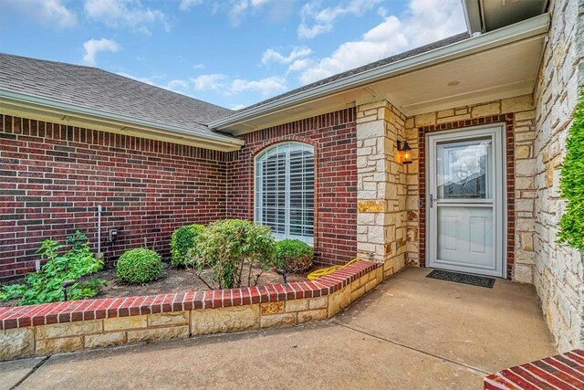 517 N Quail Run, Altus, OK 73521 - property entrance featuring brick siding and a shingled roof
