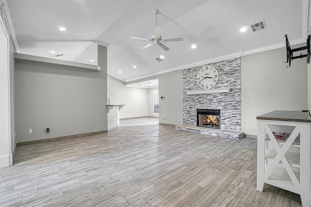 517 N Quail Run, Altus, OK 73521 - unfurnished living room featuring a ceiling fan, crown molding, a stone fireplace, lofted ceiling, and light wood finished floors