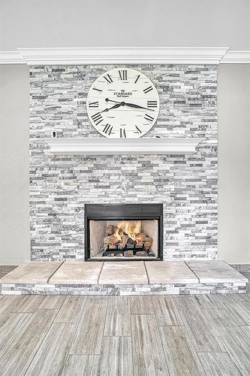 517 N Quail Run, Altus, OK 73521 - detailed view of a fireplace, ornamental molding, and wood finished floors