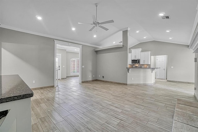 517 N Quail Run, Altus, OK 73521 - unfurnished living room featuring ceiling fan, lofted ceiling, wood finish floors, ornamental molding, and recessed lighting