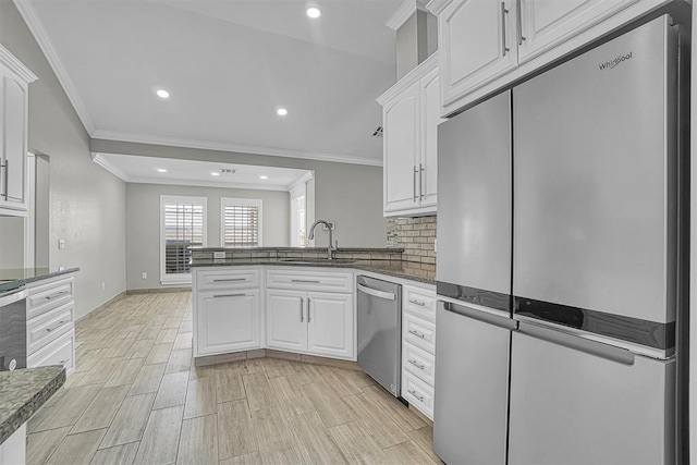 517 N Quail Run, Altus, OK 73521 - kitchen featuring stainless steel appliances, crown molding, white cabinets, a peninsula, and recessed lighting