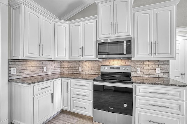517 N Quail Run, Altus, OK 73521 - kitchen with appliances with stainless steel finishes, dark stone counters, white cabinetry, ornamental molding, and backsplash