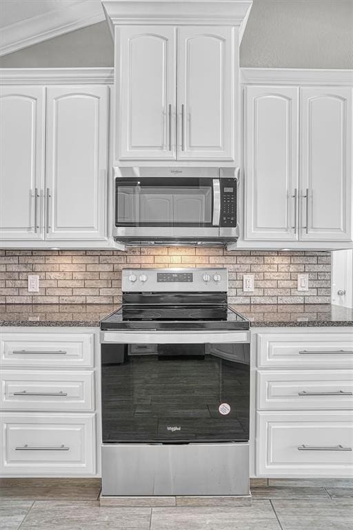517 N Quail Run, Altus, OK 73521 - kitchen with appliances with stainless steel finishes, dark stone counters, white cabinets, and backsplash