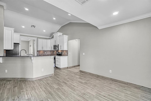 517 N Quail Run, Altus, OK 73521 - kitchen with crown molding, a peninsula, decorative backsplash, a breakfast bar area, and white cabinetry