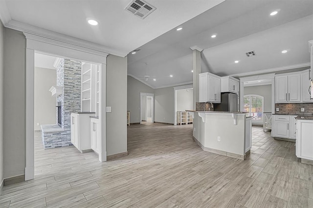 517 N Quail Run, Altus, OK 73521 - kitchen featuring crown molding, freestanding refrigerator, light wood-style floors, a kitchen bar, and white cabinets