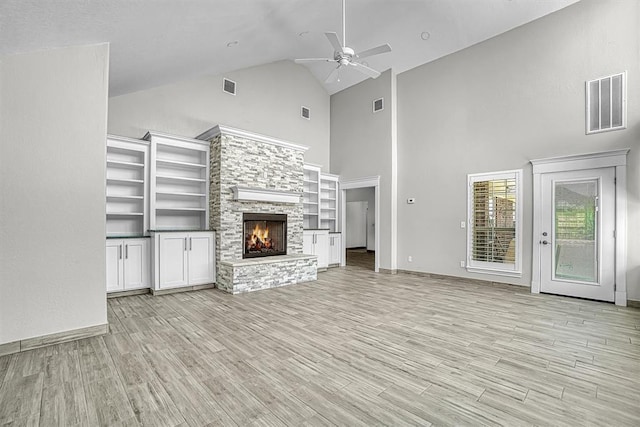517 N Quail Run, Altus, OK 73521 - unfurnished living room with high vaulted ceiling, ceiling fan, a fireplace, light wood-type flooring, and built in shelves