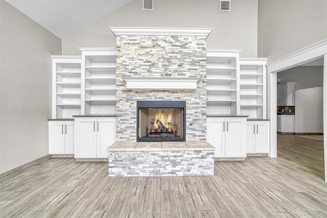 517 N Quail Run, Altus, OK 73521 - unfurnished living room featuring light wood-style flooring, a fireplace, and lofted ceiling