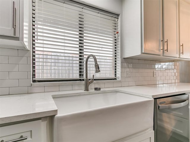 2004 Tanglewood Dr, Edmond, OK 73013 - kitchen featuring stainless steel dishwasher, backsplash, plenty of natural light, and light stone countertops