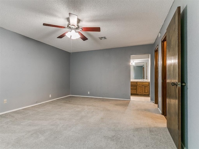 2004 Tanglewood Dr, Edmond, OK 73013 - unfurnished bedroom featuring light carpet, a textured ceiling, connected bathroom, and a ceiling fan