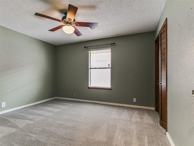 2004 Tanglewood Dr, Edmond, OK 73013 - unfurnished room with a ceiling fan, carpet, a textured ceiling, and a textured wall