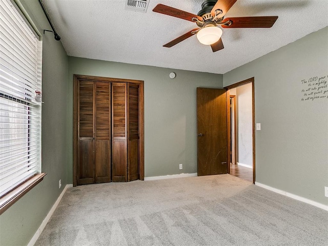 2004 Tanglewood Dr, Edmond, OK 73013 - unfurnished bedroom with a textured ceiling, a closet, carpet, and ceiling fan