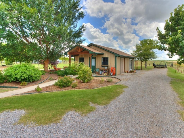 1616 E Cottonwood Rd, Goldsby, OK 73093 - view of front facade with gravel driveway, a garage, and board and batten siding