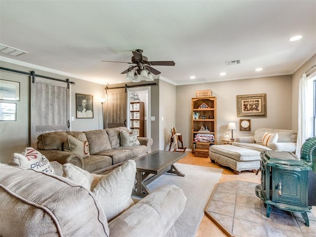 1616 E Cottonwood Rd, Goldsby, OK 73093 - living room featuring a barn door, light wood-type flooring, crown molding, recessed lighting, and a ceiling fan