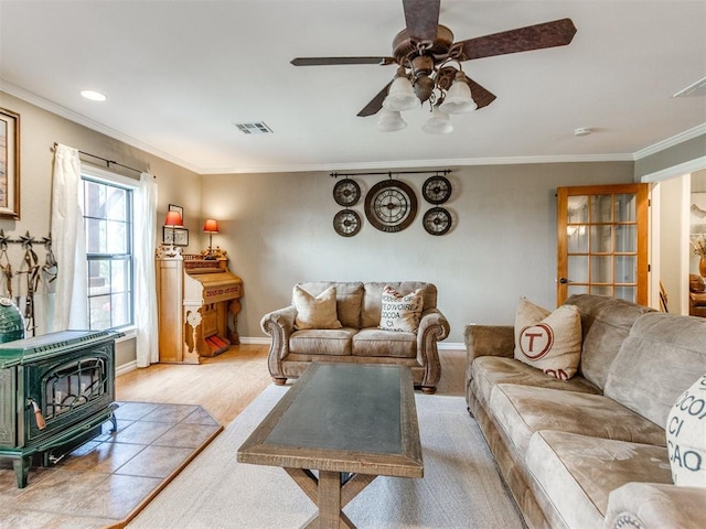 1616 E Cottonwood Rd, Goldsby, OK 73093 - living room featuring a wood stove, ornamental molding, ceiling fan, and light wood-style floors
