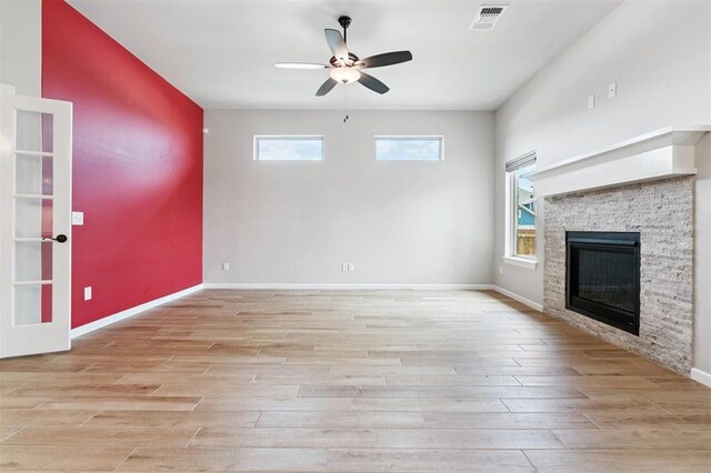 9233 NW 91st St, Yukon, OK 73099 - unfurnished living room featuring light wood-style floors, a ceiling fan, and a fireplace