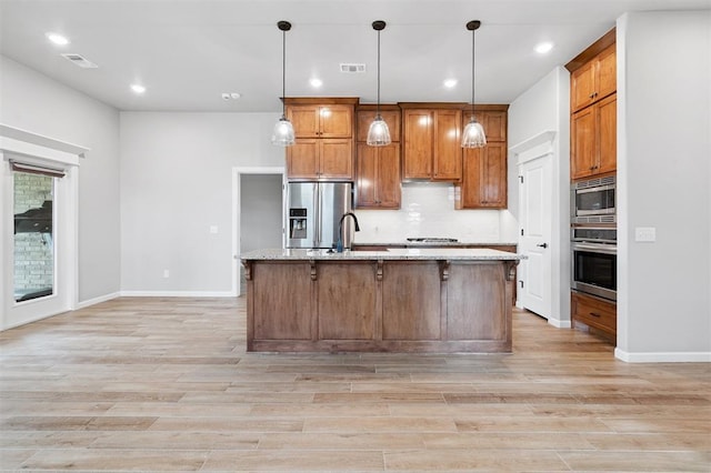 9233 NW 91st St, Yukon, OK 73099 - kitchen with stainless steel appliances, light wood-type flooring, brown cabinetry, tasteful backsplash, and recessed lighting