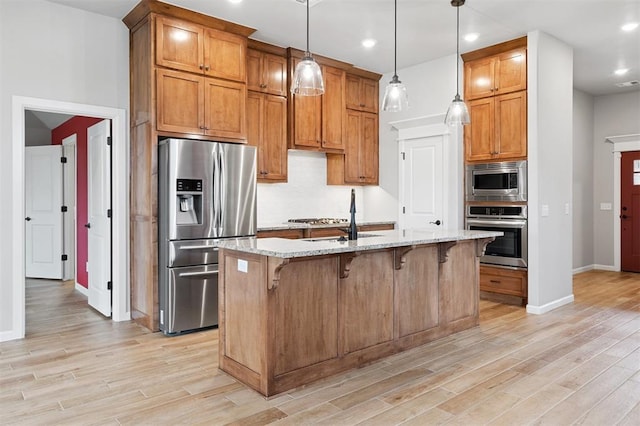 9233 NW 91st St, Yukon, OK 73099 - kitchen featuring stainless steel appliances, light stone counters, a breakfast bar area, light wood-type flooring, and recessed lighting